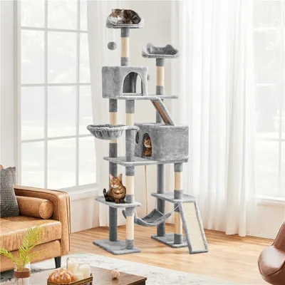 A multi-level cat tree with several cats on it, placed in a living room setting near a window and a sofa.