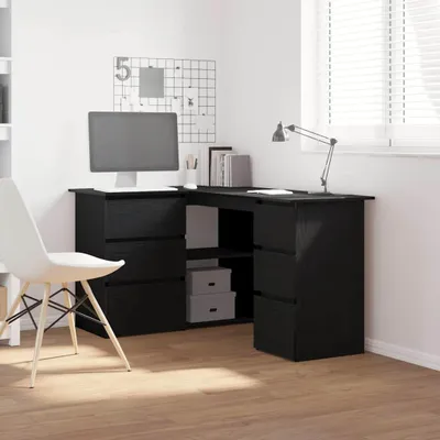 A modern black corner desk setup in a room with a white wall and wooden floor.