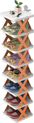 A multi-tiered shoe rack filled with various shoes and a small plant on the top shelf.
