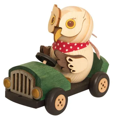 A wooden owl figurine driving a green toy car.