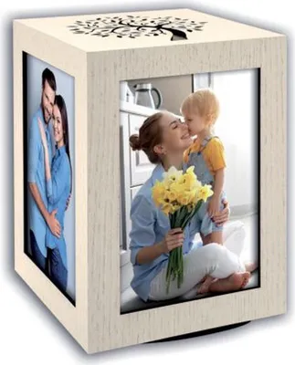A wooden photo cube with two pictures displayed, one of a couple and another of a mother and child, with a tree design on top.
