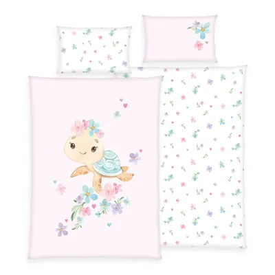 A set of bedding with a watercolor illustration of a turtle wearing a flower crown, surrounded by flowers and hearts, on a pink background. There are also two pillowcases with a floral pattern.