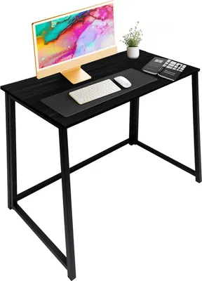 A black folding desk with a computer monitor, keyboard, mouse, calculator, and a small plant.