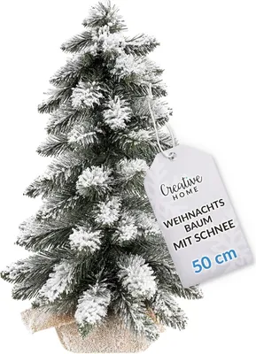 A small artificial Christmas tree with snow-like flocking, standing in a decorative pot, with a product tag attached.