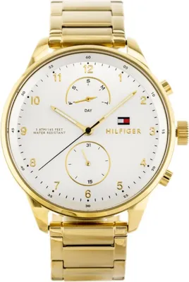 A close-up studio shot of a gold Tommy Hilfiger watch with a white face.