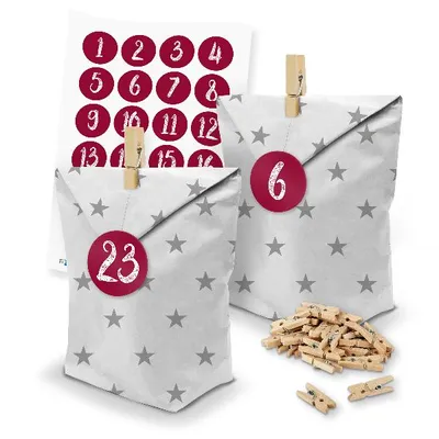 A set of advent calendar bags with stars, clothespins, and number stickers.