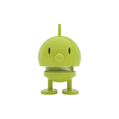 A small, lime green toy with a round head and two legs, standing on a white background.