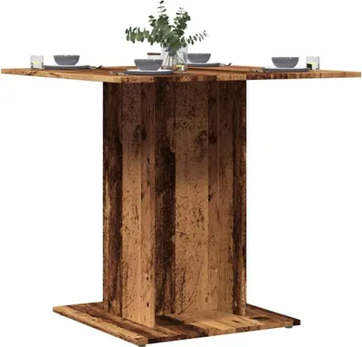 A wooden dining table with bowls and a vase of plants on top.