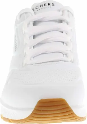 A close-up, front-facing view of a white sneaker with a gum sole.