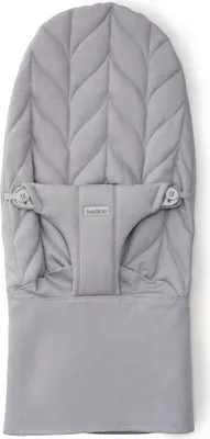 A light gray baby bouncer cover with a leaf-like quilted pattern.