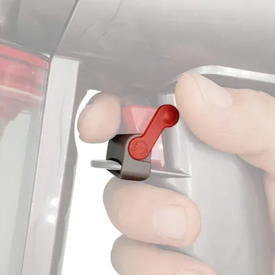 A close-up shot of a person's fingers operating a red and gray switch on a vacuum cleaner.