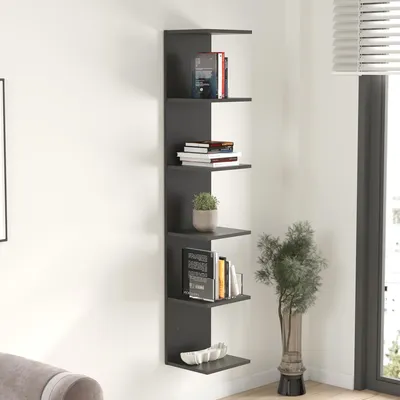 A dark gray corner shelf unit with books, a plant, and decorative items.