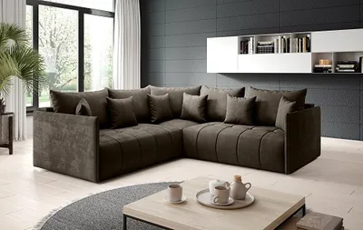 A modern living room with a large sectional sofa, coffee table, and shelves on the wall.
