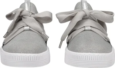 A pair of silver Puma sneakers with large ribbon bows.