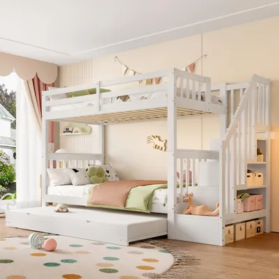 A white bunk bed with a pull-out trundle bed in a child's bedroom.