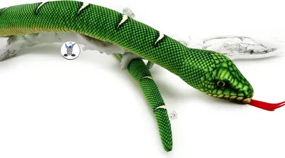 A plush green snake with a red tongue is draped over a white branch against a white background.