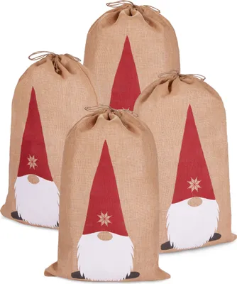 Four burlap Christmas sacks with gnome designs are arranged together.