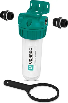 A water filter housing with accessories and a wrench, displayed against a white background.