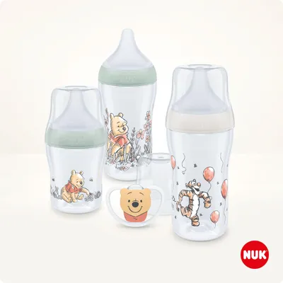 A collection of baby bottles and a pacifier featuring Winnie the Pooh and Tigger characters.