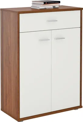 A studio shot of a wooden and white cabinet with a drawer and two doors, with books stacked on top.