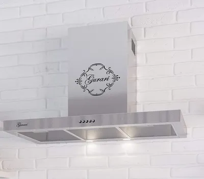 A stainless steel range hood mounted on a white brick wall.