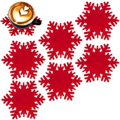 A set of red snowflake-shaped coasters with a cup of coffee on one of them.