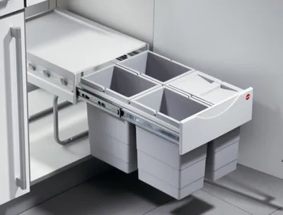 A pull-out kitchen waste bin system with multiple compartments, installed inside a cabinet.