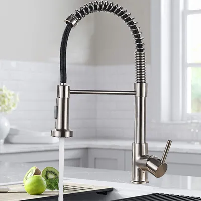 A kitchen faucet with water running, in a kitchen setting.
