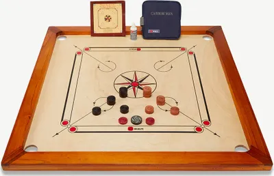 A carrom board game set with pieces and accessories arranged on the board.
