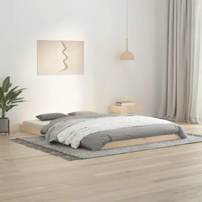 A bedroom scene with a bed, a plant, and a painting on the wall.