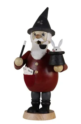 Zauberer mit seinem Zauberstab und dem aus dem Hut springenden Kaninchen. Spielkarten in der Tasche.