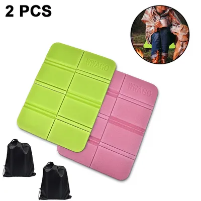 Two foldable foam seat cushions, one green and one pink, are shown in the foreground. Two black drawstring bags are in the bottom left corner. A circular inset image in the top right shows a person and a dog sitting by a campfire.