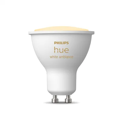 A white Philips Hue smart light bulb with a yellow light emission is shown against a white background.