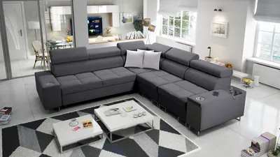 A modern living room with a large sectional sofa, coffee tables, and a rug.