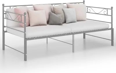 A metal daybed with several throw pillows.