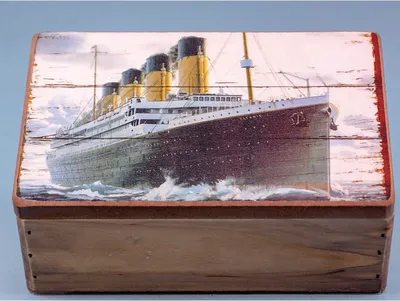 A wooden box with a printed image of the Titanic ship on its lid.