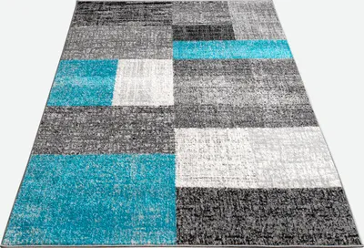 A close-up, angled view of a modern rug with a geometric pattern.