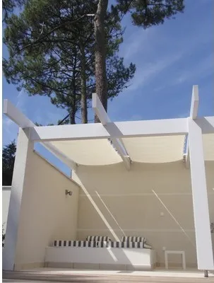 An outdoor seating area with a white pergola and a built-in bench with striped cushions.