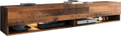 A long, wooden TV lowboard with open shelves, displaying electronic devices and accessories.
