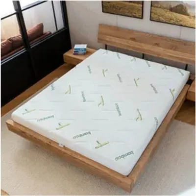 A mattress is placed on a wooden bed frame in a room.