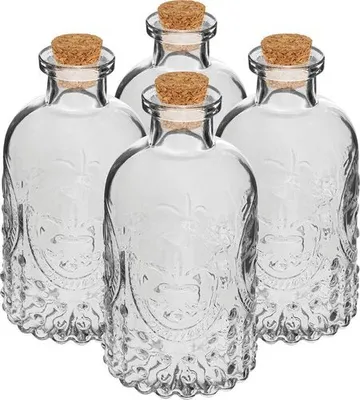 Four clear glass bottles with cork stoppers are arranged in a group on a white background.