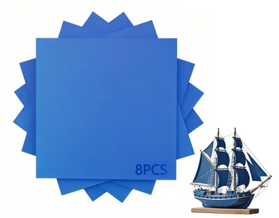 A stack of blue square sheets and a model ship.