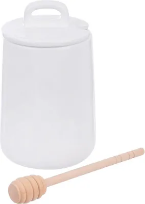 A white ceramic honey pot with a lid and a wooden honey dipper.