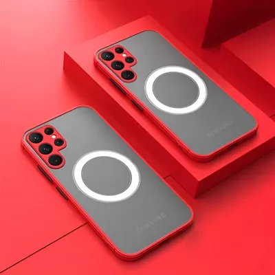 Two red-rimmed, clear phone cases with a white magnetic ring are displayed on a red surface, with one case resting on a red platform.