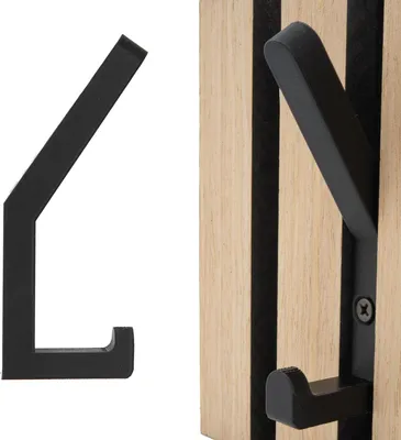 A black hook is shown on a white background next to a wooden panel with black stripes and a black hook attached.