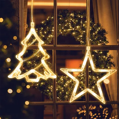 Christmas decorations hanging in a window at night.