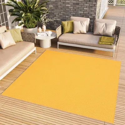 An outdoor patio scene with furniture and a rug.