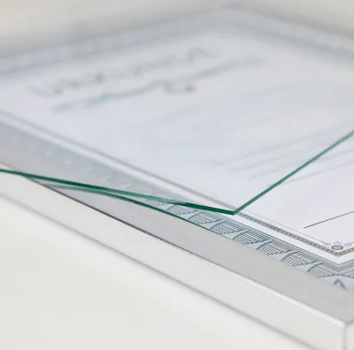 A close-up shot of a silver picture frame with a certificate inside, viewed from a slight angle.