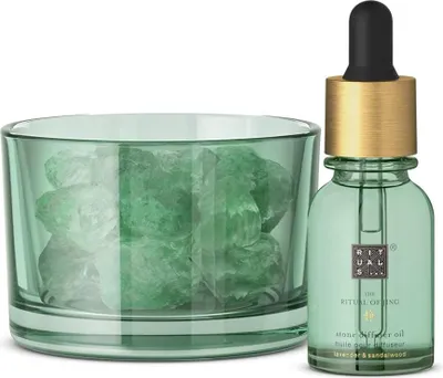 A diffuser oil bottle and a glass container with mineral stones.