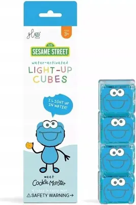 A product package for Sesame Street water-activated light-up cubes featuring Cookie Monster, with a stack of the cubes shown to the right.